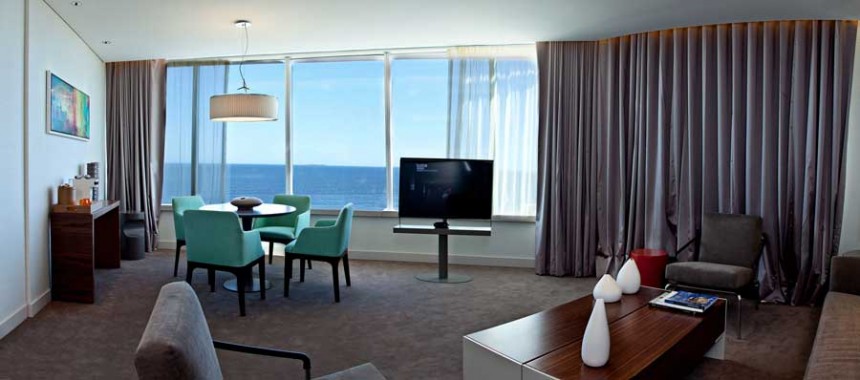 Las habitaciones del Hotel The Grand cuentan con muebles de diseño y grandiosos vistas al mar desde sus grandes ventanas.